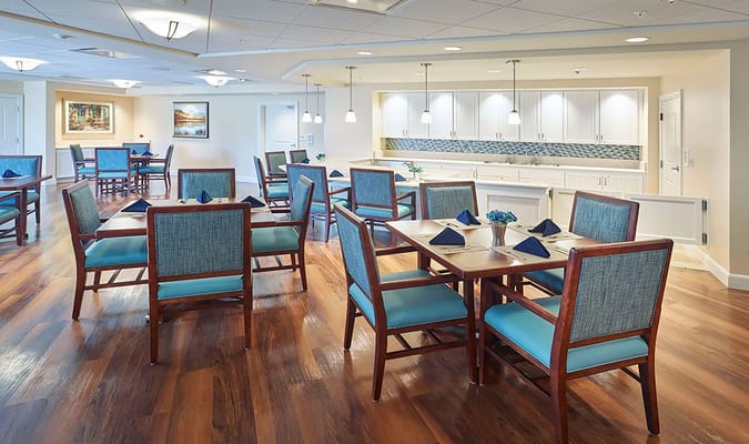 Spacious dining area with wooden tables and blue-accented chairs