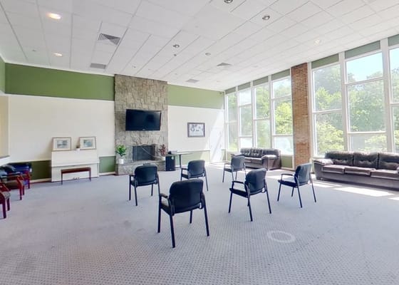 Bright common area with black chairs and a stone fireplace