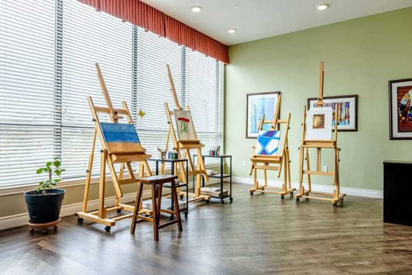 Art easels displaying paintings in a bright studio