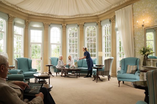 Residents and caregiver interacting in a bright living room