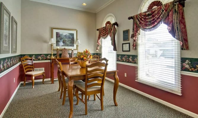 Dining table surrounded by chairs and floral decor.