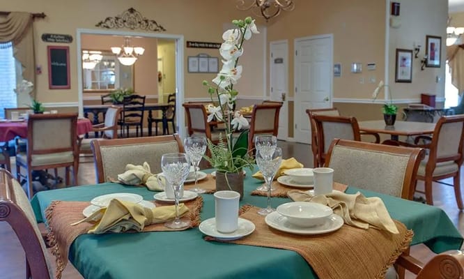 Decoratively set dining table with floral centerpiece in a senior living facility