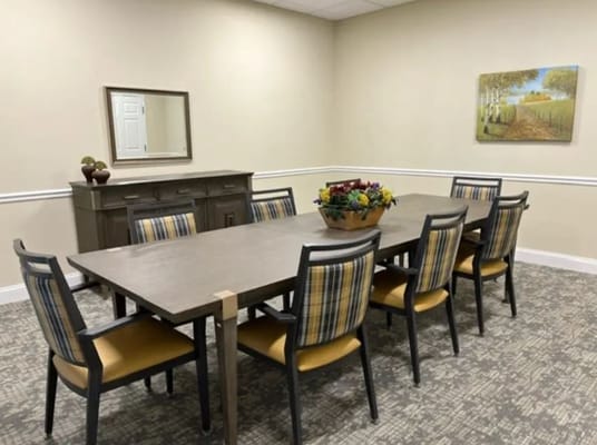 Spacious dining room with a long table and chairs.
