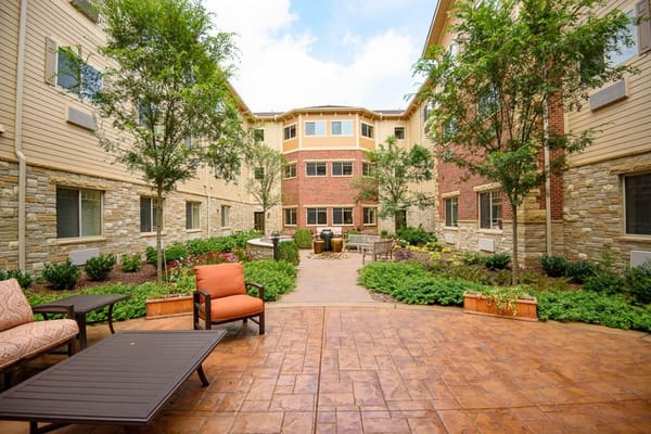 Outdoor courtyard with seating and greenery at The Bridge at Hickory Woods.