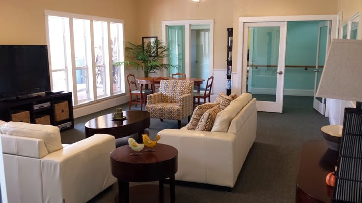 Spacious living room with white sofas and dining area