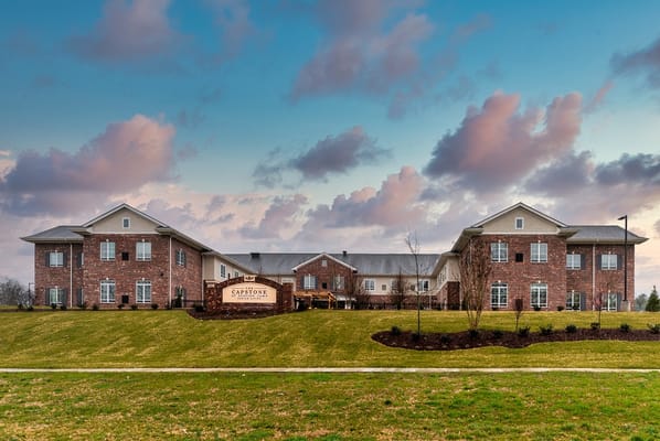 The Capstone at Station Camp building exterior with landscaped lawn and cloudy sky