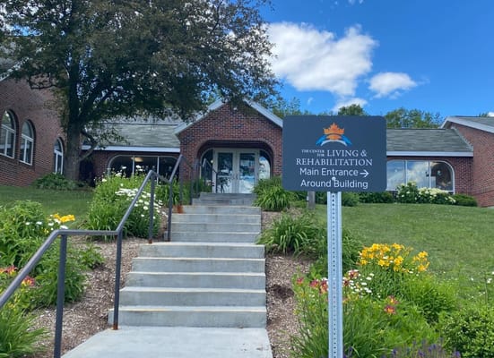 Steps leading to the main entrance of The Center for Living and Rehabilitation with a sign
