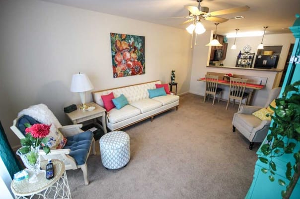 Spacious living room with a beige couch, colorful pillows, and artwork.