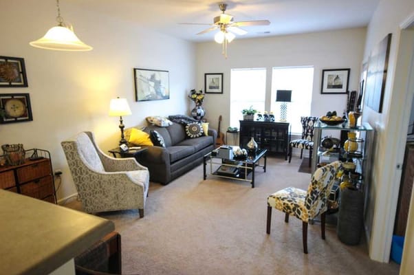 Living room with sofa, decorative chairs, and natural light
