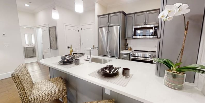 Modern kitchen with gray cabinetry and dining area