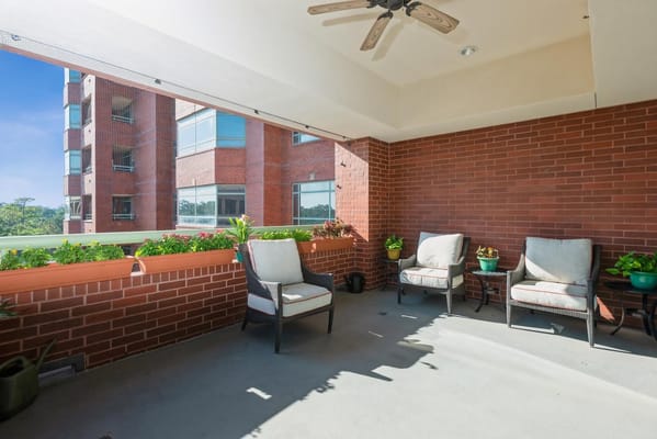 Balcony with seating and plants at The Forum at Memorial Woods.