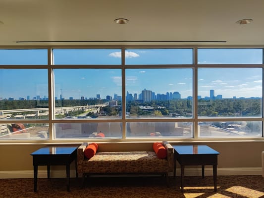 View of Houston skyline from a large window with seating area