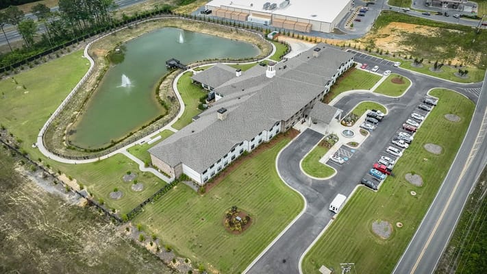 Aerial view of The Fountains senior living facility with pond and gardens.