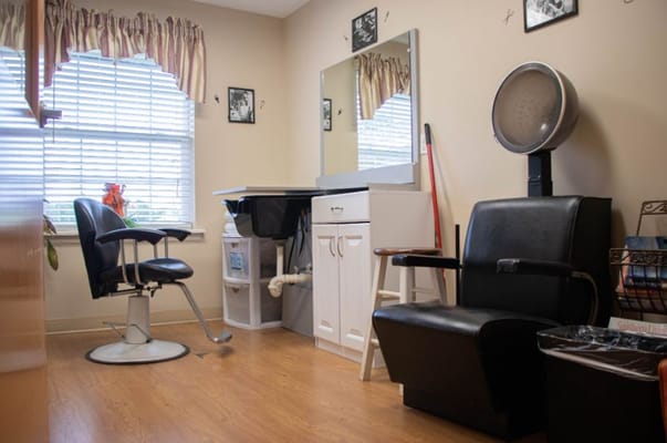 Hair salon with a styling chair, mirror, and dryer