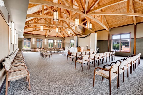 Spacious community room with wooden beams and chairs arranged in rows