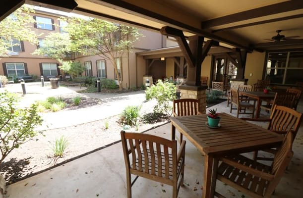 Outdoor seating area with wooden tables and chairs at The Isle at Cedar Ridge
