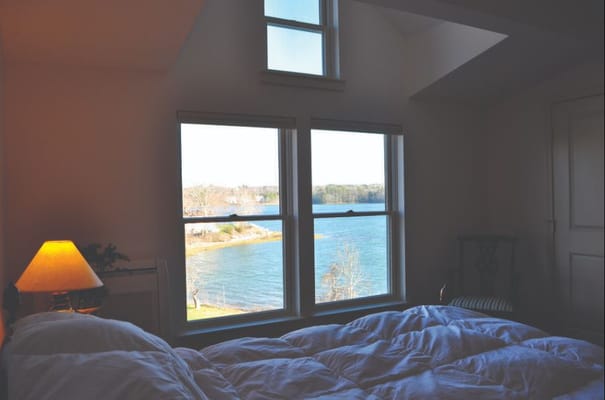 Cozy bedroom with a view of the river through large windows