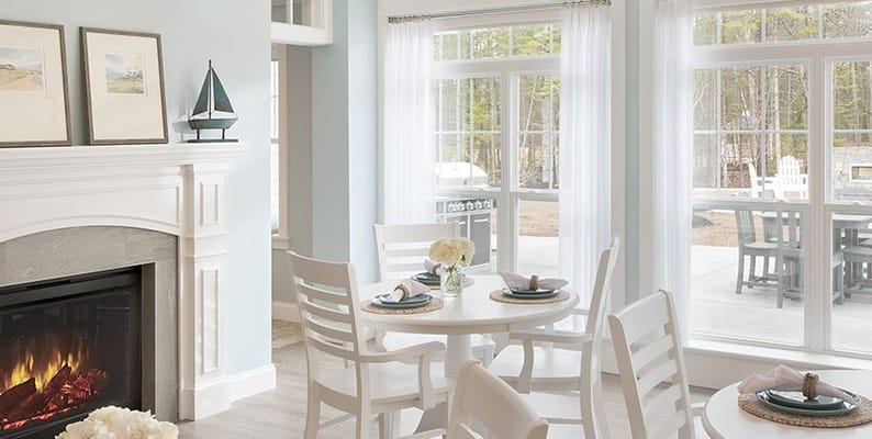 Bright dining area with a fireplace and large windows