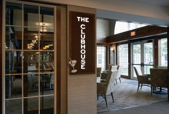 Entrance to The Clubhouse with chairs and a sign