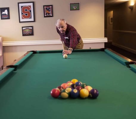 Senior resident lining up a shot at the billiards table