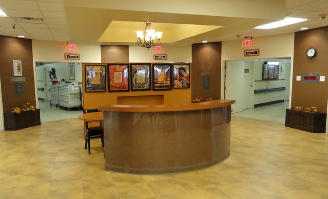Interior view of the reception area with a desk, artwork, and hallways.