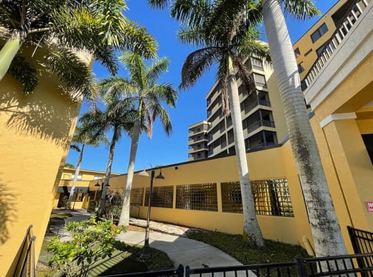 View of the courtyard surrounded by palm trees and buildings at The Palms at Sebring.