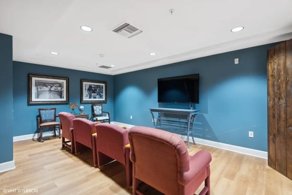 Cozy lounge area with chairs and TV in a senior living facility