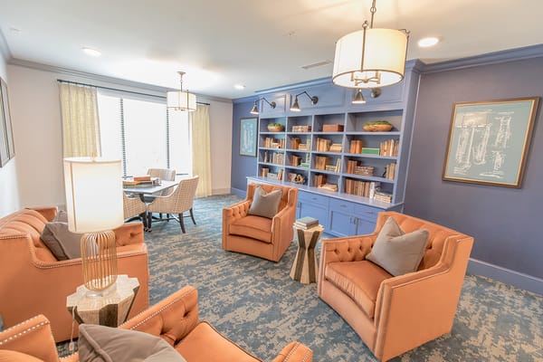 Living room with orange chairs and bookshelves
