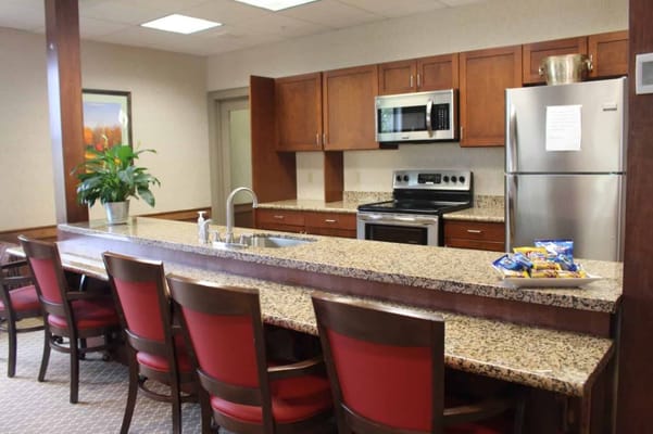 Spacious kitchen with granite countertop and red chairs