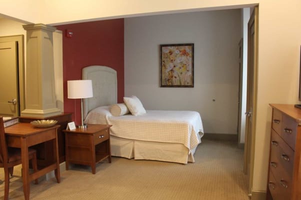 Interior view of a bedroom with a single bed and wooden furniture