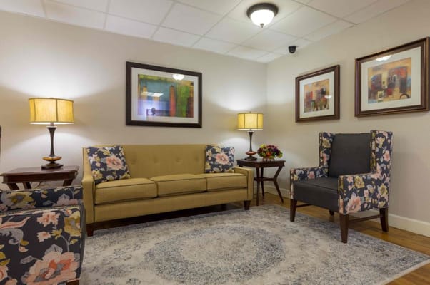 A cozy living room area with floral chairs and a sofa