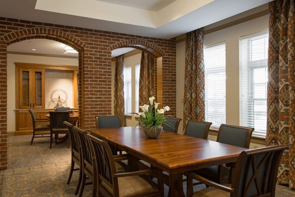 Dining area with a large wooden table and floral centerpiece