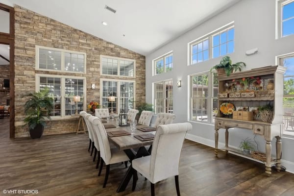 Bright dining area with a long table and decorative shelves