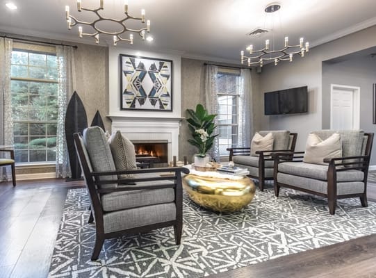 Stylish living room with two armchairs, a gold coffee table, and a fireplace.