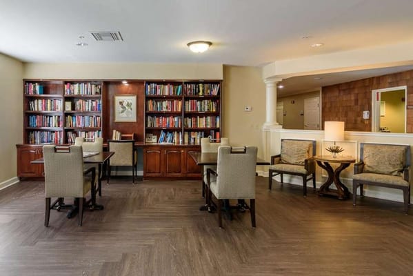 Cozy library area with bookshelves and seating in a senior living facility