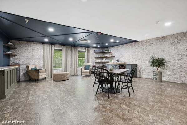 Cozy common area with seating and dining space in a senior living facility.