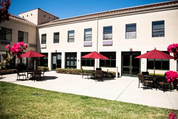 Exterior view of a courtyard with umbrellas and seating