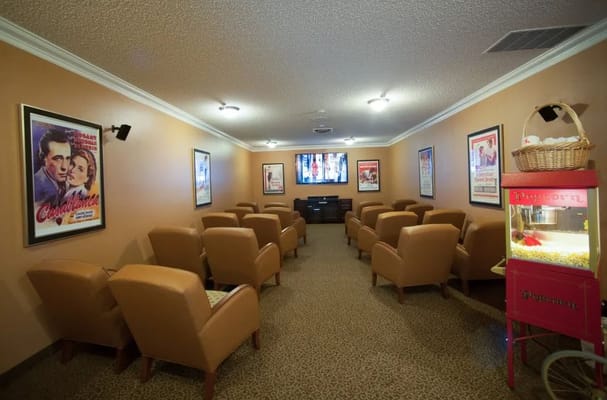 Interior of a movie room with seating and popcorn machine