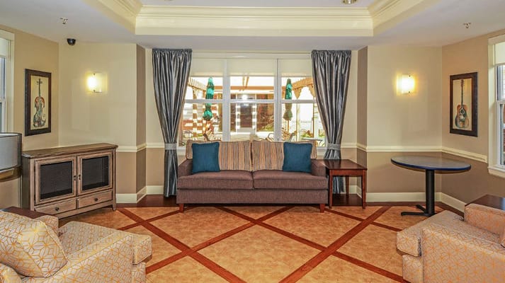 Cozy living room with a sofa and armchairs at The Rutherford Memory Care facility