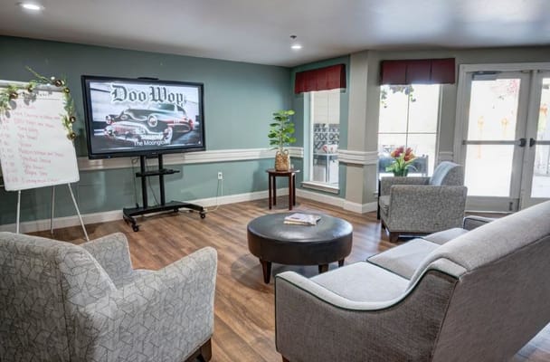 Seating area with a TV displaying a classic car image.