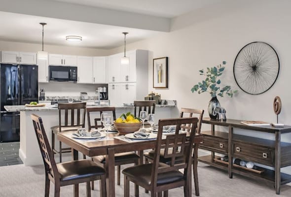 Modern kitchen and dining area with wooden table and chairs.