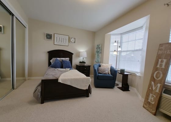 Bright bedroom with a bed, chair, and decorative items