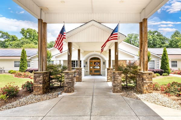 Front entrance of The Waterford at Decatur with flags and landscaping