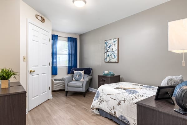 Quiet bedroom with floral bedding and armchair