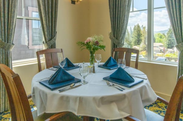 Elegantly set dining table with blue napkins and a flower centerpiece