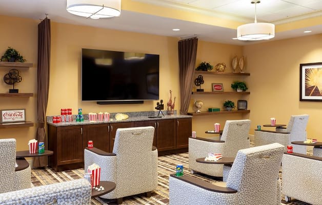 Cozy lounge with seating, popcorn, and a large TV