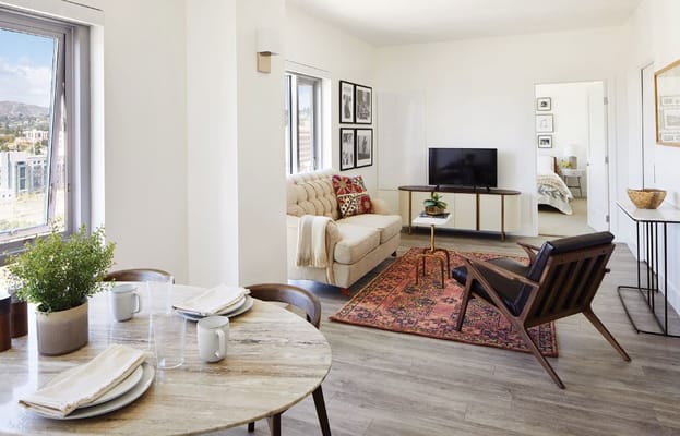 A welcoming living room with a sofa, TV, and dining table.