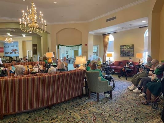 A cozy lounge area with residents sitting together on sofas and chairs.