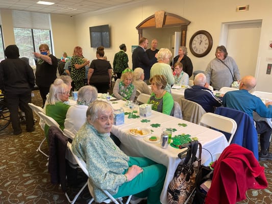 Residents enjoying a St. Patrick's Day event with decorations and refreshments.