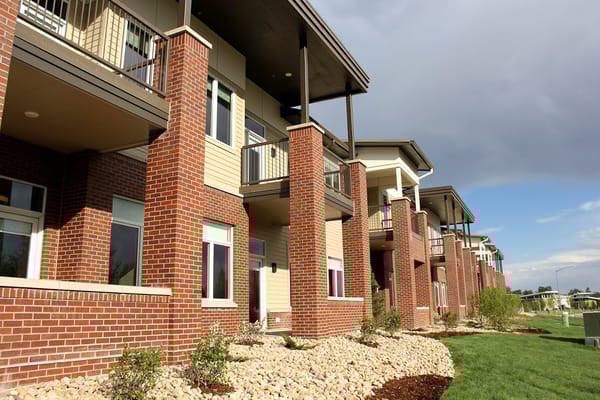 Exterior of The Windsor Independent Living facility with brick columns and balconies.